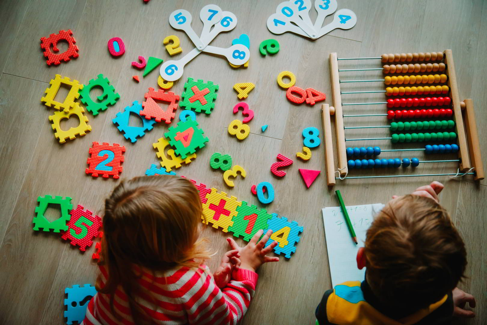 little boy and girl learn to write and calculate numbers